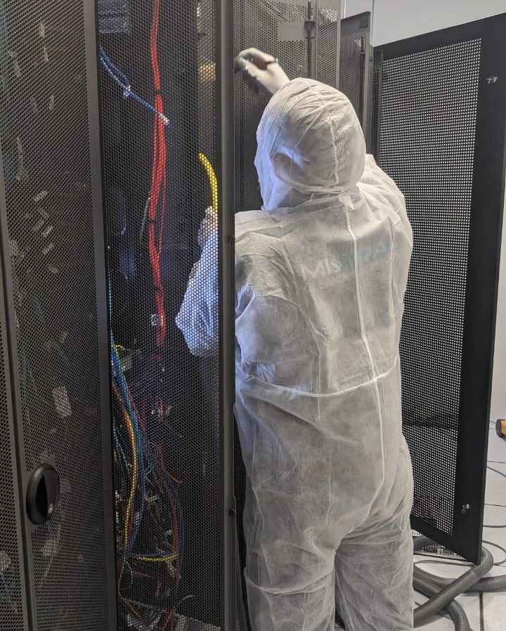 Technician performing data center cleaning on server rack