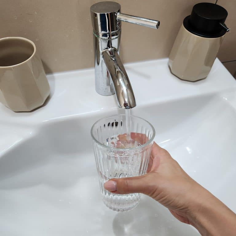 Lady filling a glass of tap water in Dubai for drinking