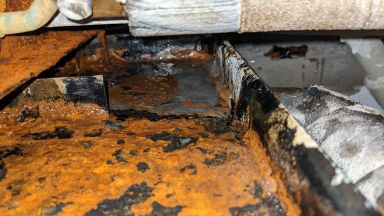 rusted and damaged drain pan causing AC leakage