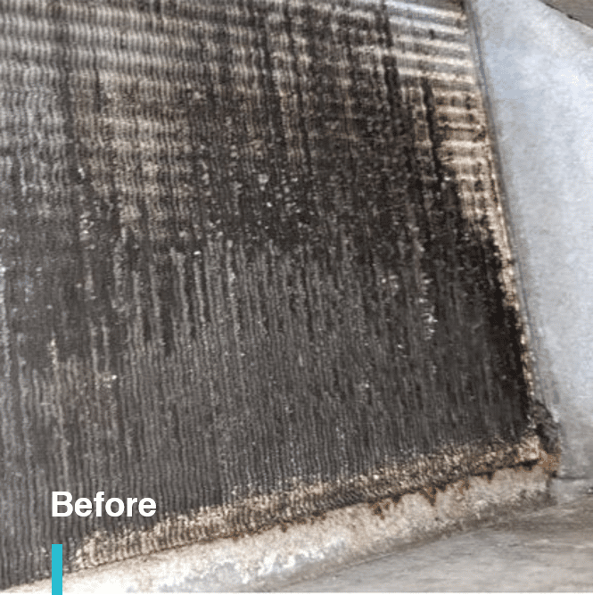 Dirty AC coil with accumulated mud before cleaning with pressure washer